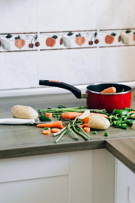 mixed vegetables and cooking pot on kitchen counter