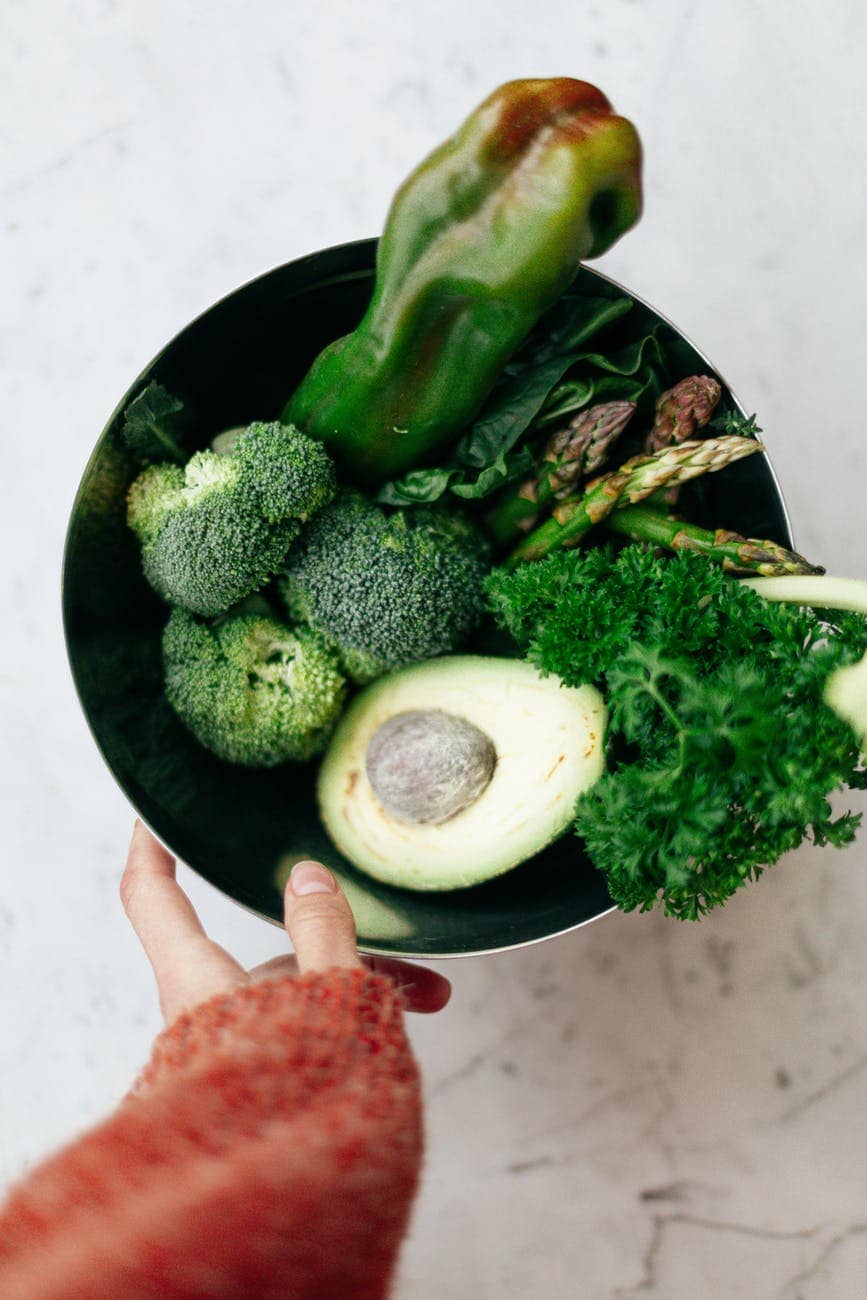 green vegetables and fruit in a bowl